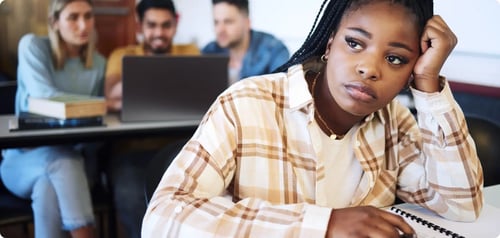 A diverse group of students all working at a desk together