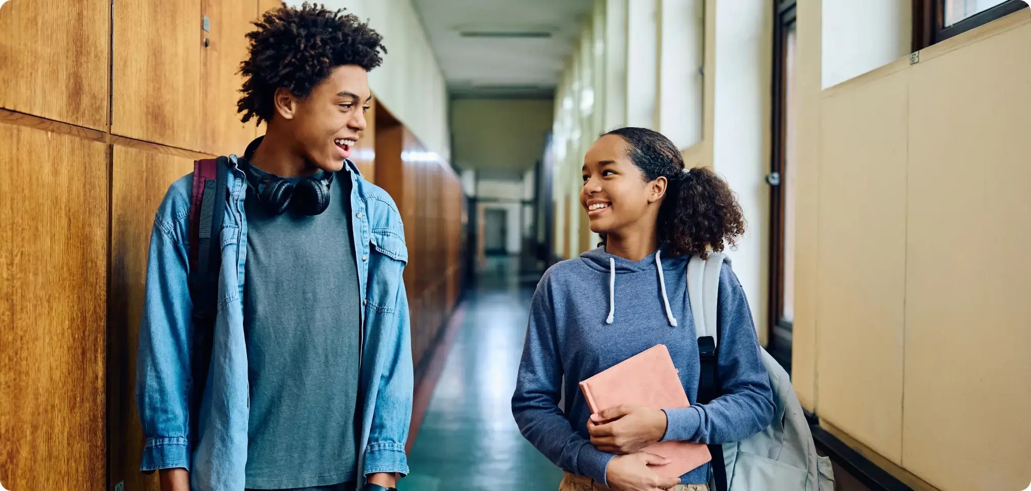 a student walking into a school smiling