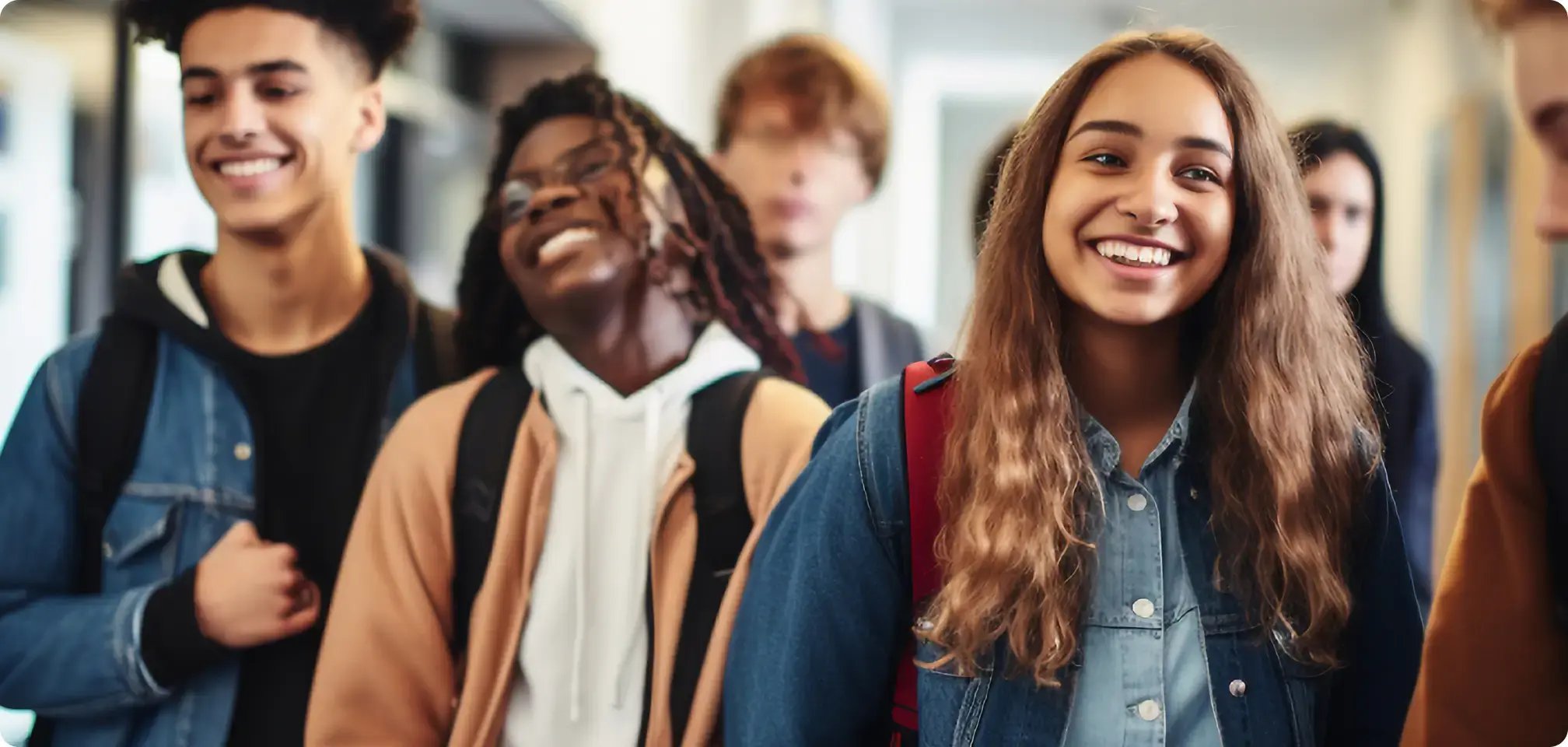 a group of students smiling together with backpacks on at school