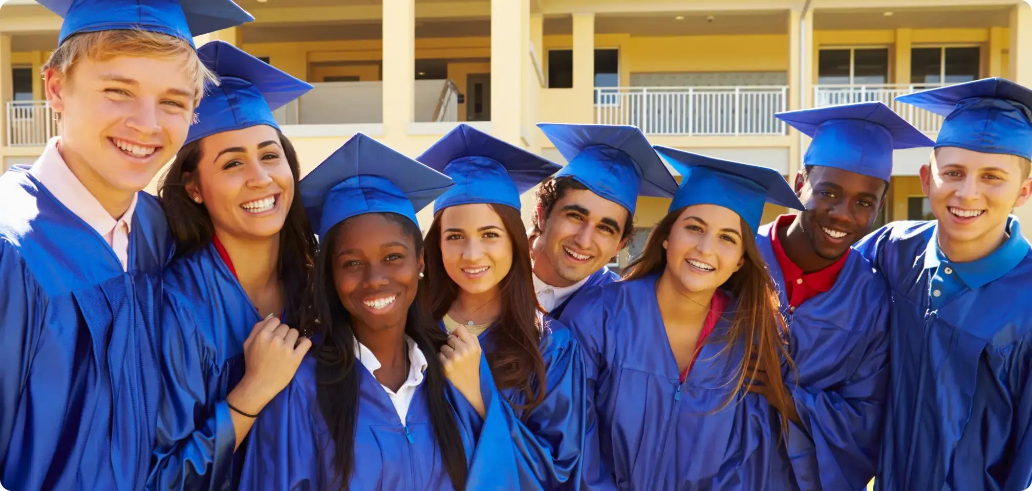 students in graduation gown smiling