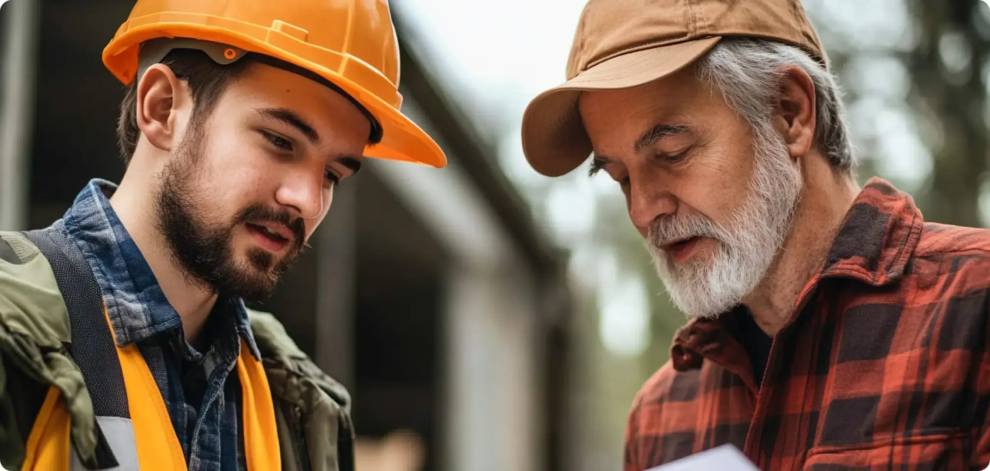 a student in construction hat learning from older man