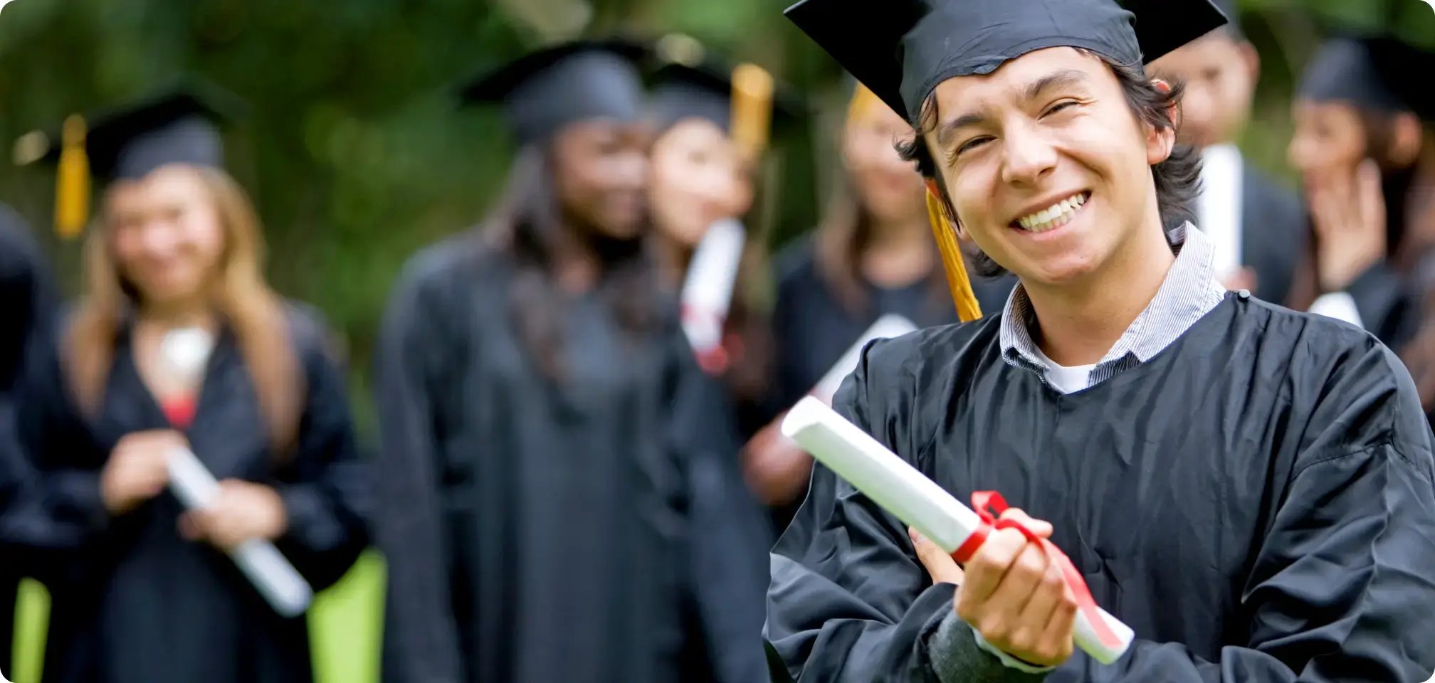 students smiling in graduation gowns