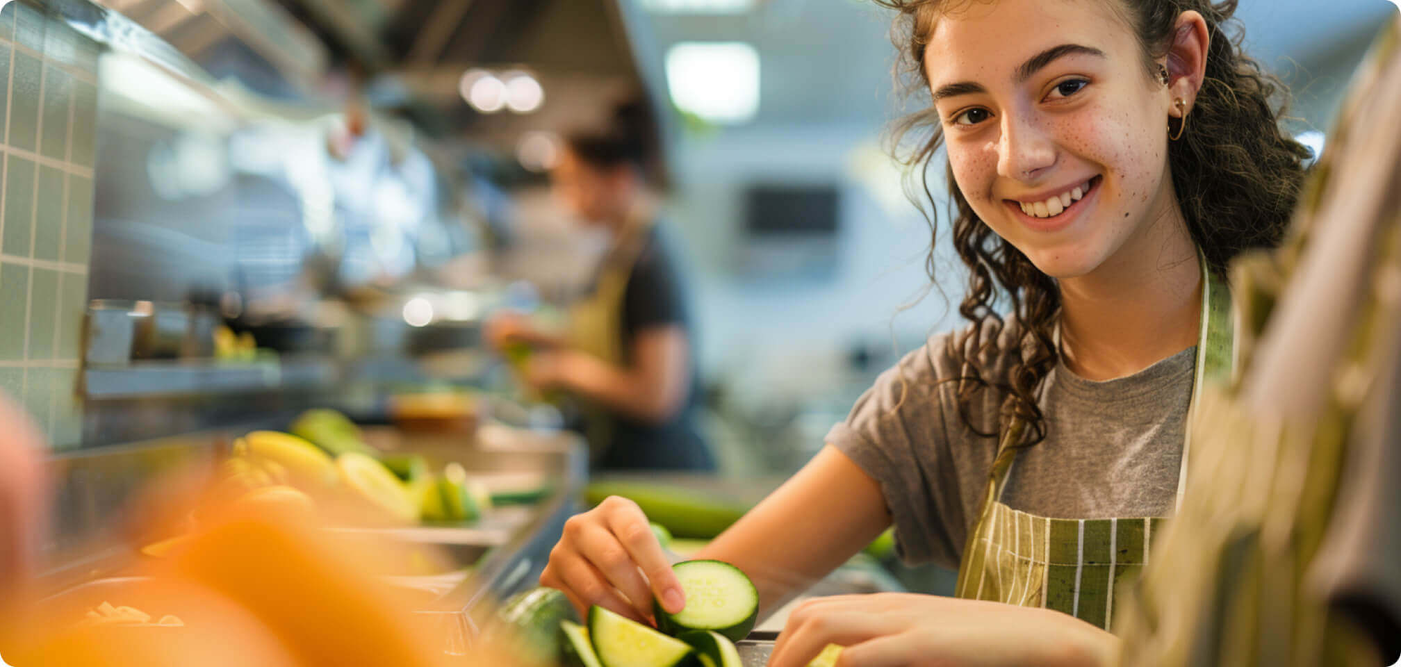 a student in preparing food and smiling