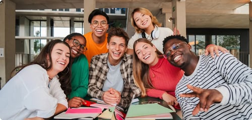 A diverse group of students all working at a desk together