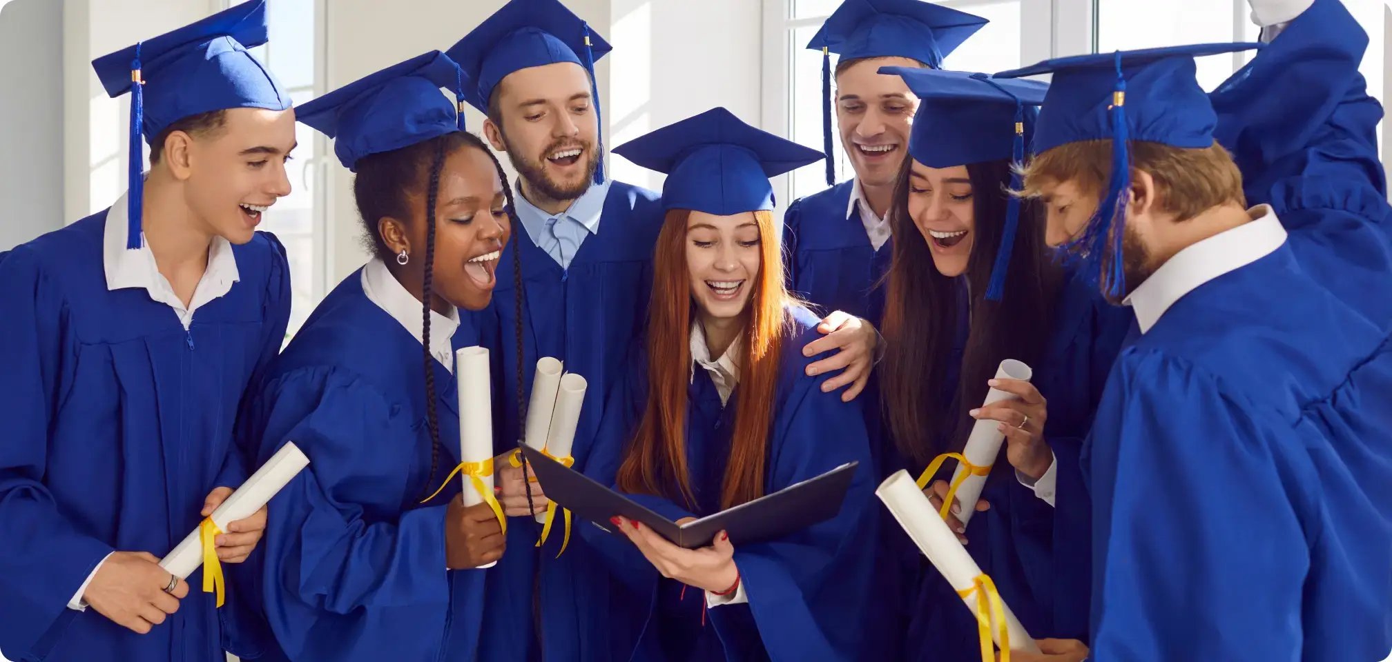 students smiling in graduation gowns