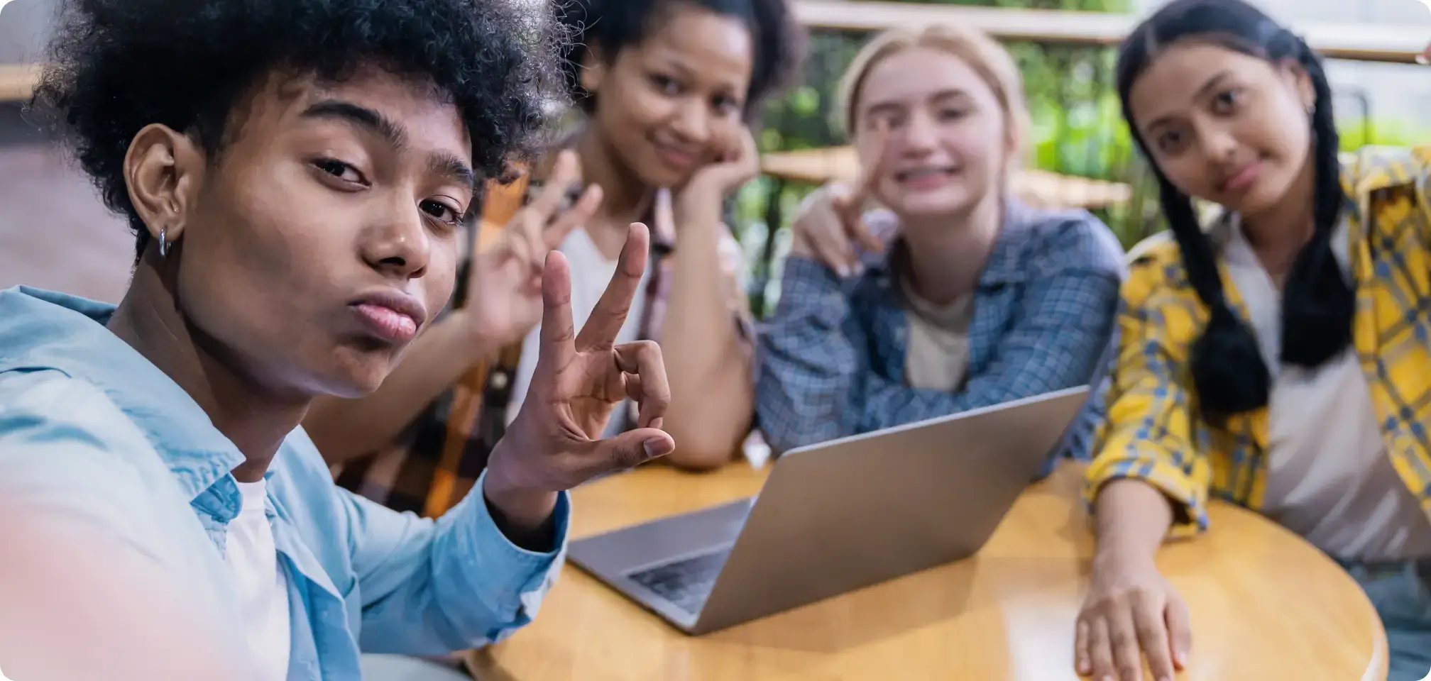 diverse group of students all working at a desk together