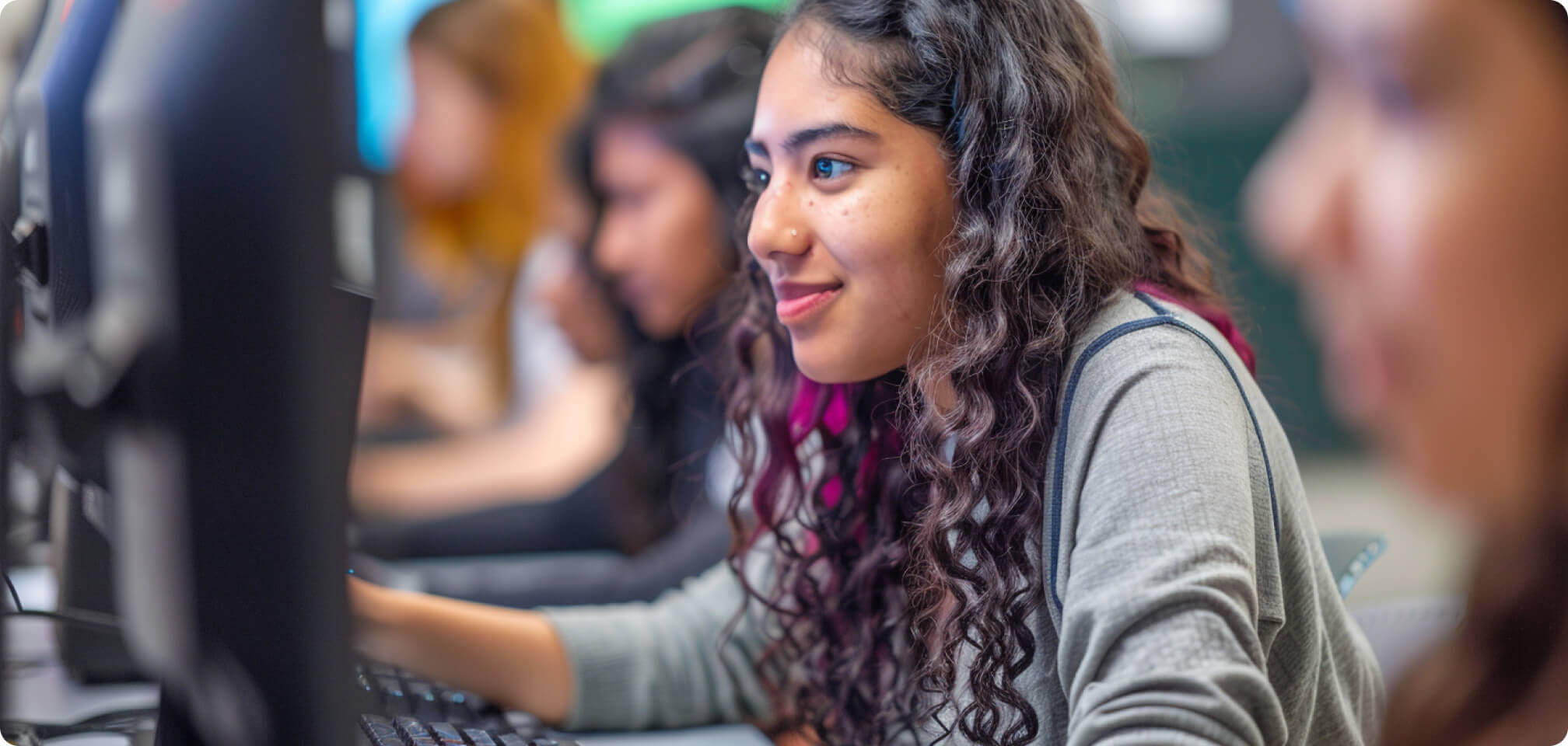 a student looking happily at a computer screen