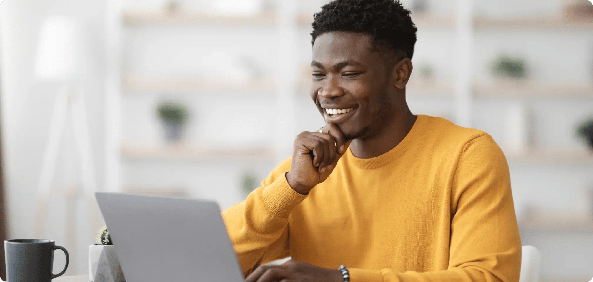 a student studying with a computer next to them looking happy