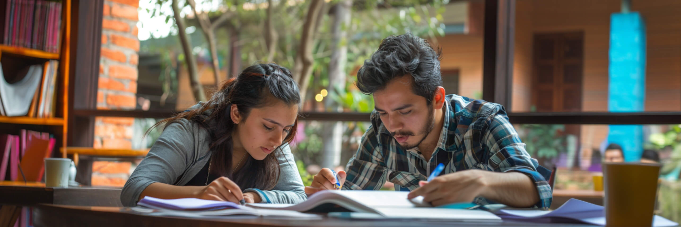 a student student with a tutor and studying a textbook 