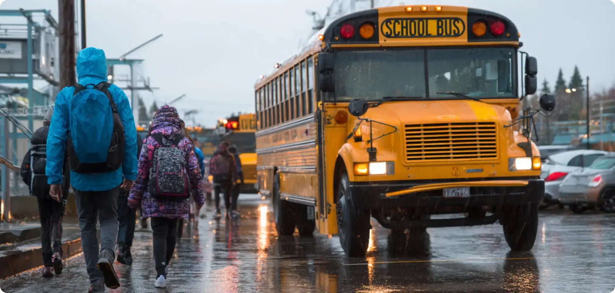 students unloading off bus at school parking lot