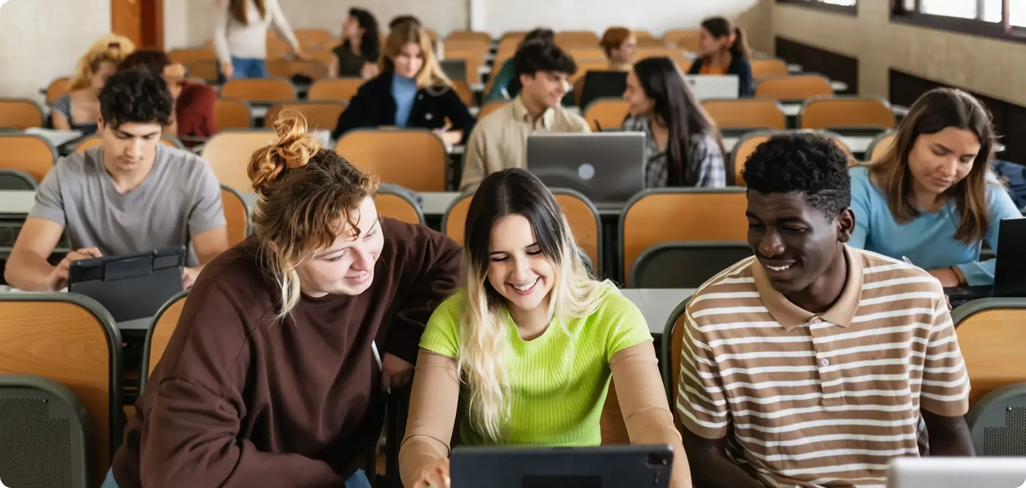 a diverse group of students all working at a desk together